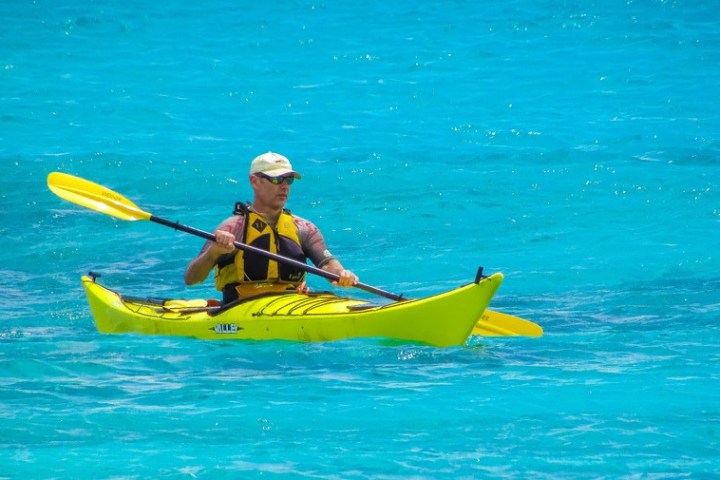 a man riding on the back of a boat in the water