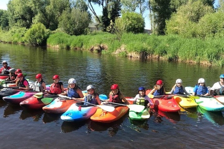 a group of people riding on the back of a boat on a river